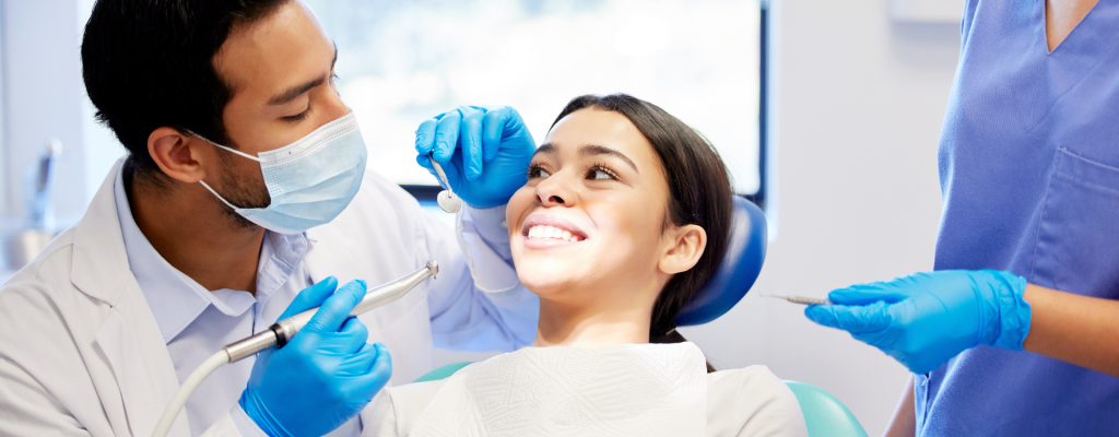 Doctor realizando un procedimiento de blanqueamiento dental.